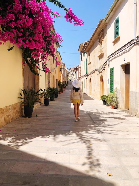 Foto vista trasera de una mujer caminando por la calle en mallorca, españa