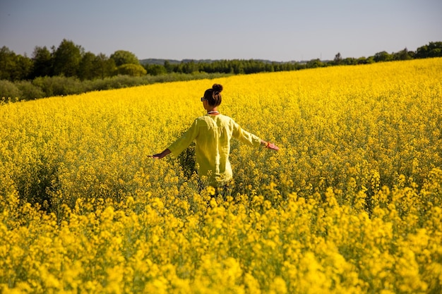 Foto vista trasera de una mujer caminando en el campo de la violación