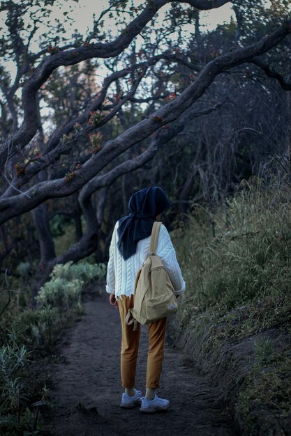 Foto vista trasera de una mujer caminando por el campo