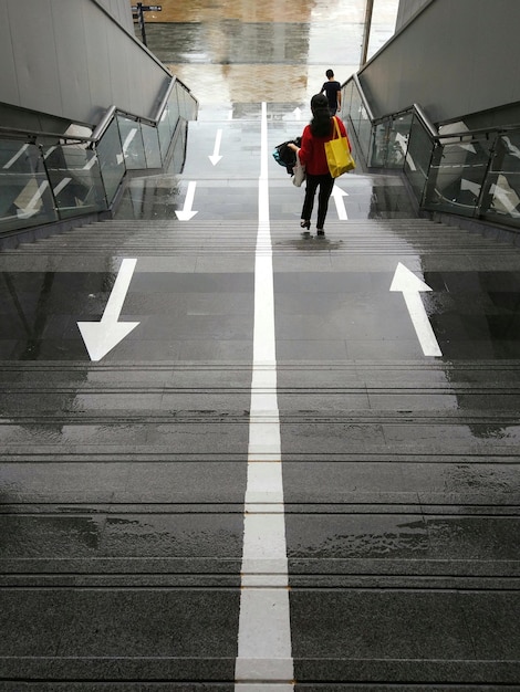 Vista trasera de una mujer caminando por las escaleras