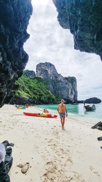 Foto vista trasera de una mujer caminando por la playa