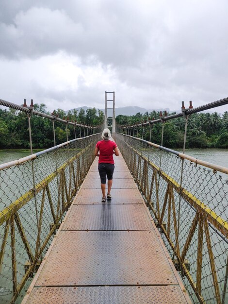 Vista trasera de una mujer caminando por el puente