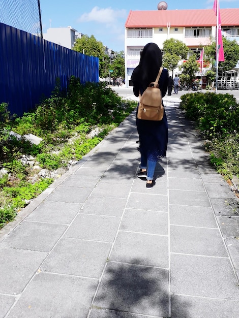 Foto vista trasera de una mujer caminando por el sendero