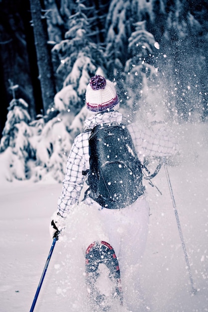 Foto vista trasera de una mujer caminando por un terreno cubierto de nieve