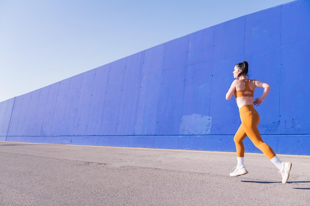 vista trasera de una mujer caucásica en forma corriendo en una pista urbana concepto de deporte y estilo de vida activo espacio para copiar texto