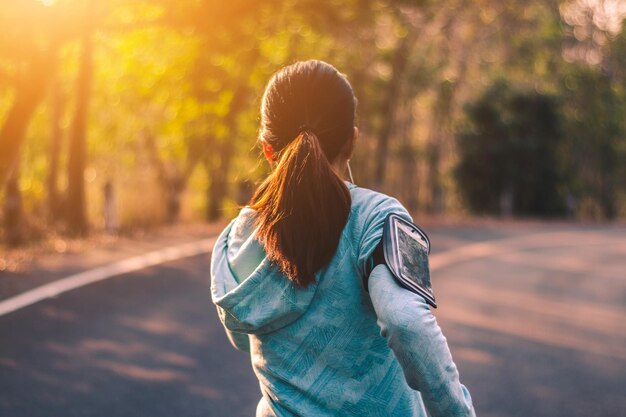 Vista trasera de una mujer corriendo por la carretera