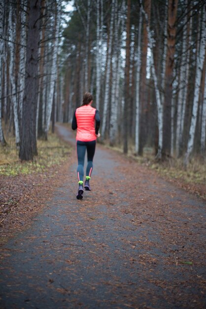 Foto vista trasera de una mujer corriendo por el sendero