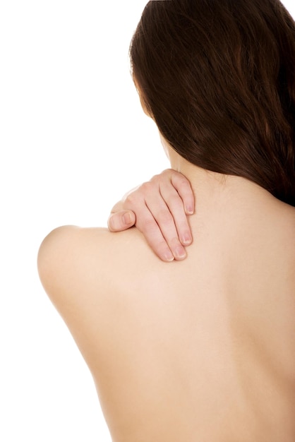 Vista trasera de una mujer con dolor de espalda sobre un fondo blanco