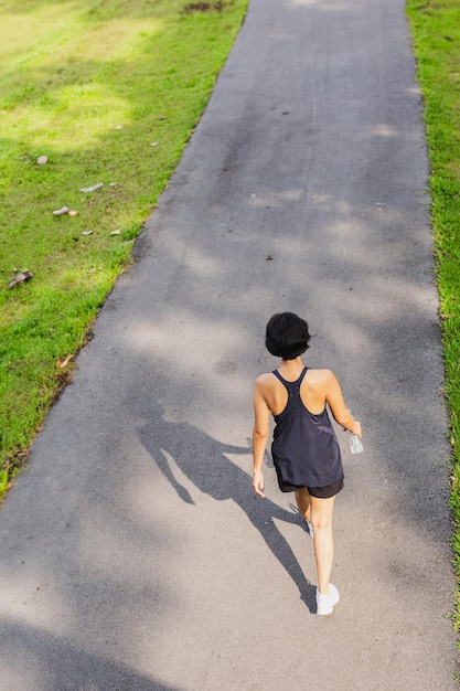 Foto vista trasera mujer ejercicio caminando en el parque