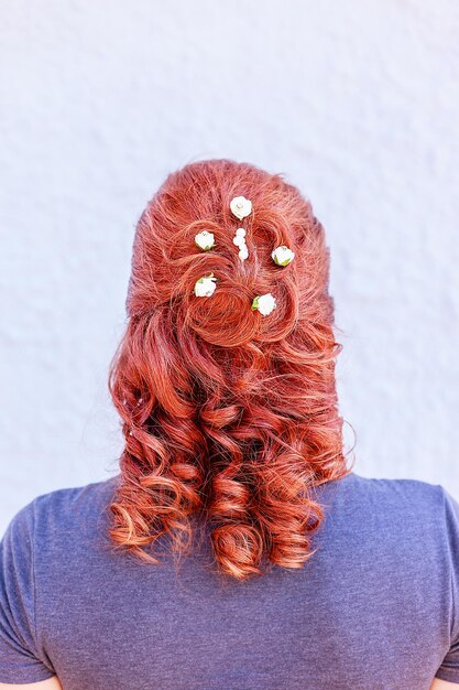 Vista trasera de una mujer con flores en el cabello