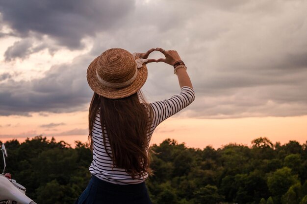 Foto vista trasera de una mujer gestando hacia el cielo nublado