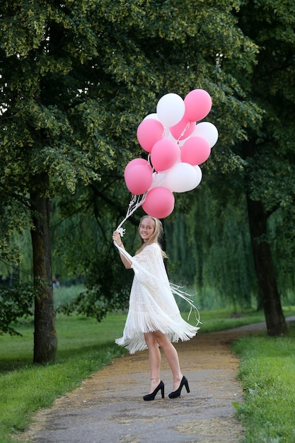 Foto vista trasera de una mujer con globos contra los árboles