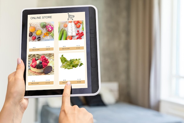 Vista trasera de una mujer haciendo compras en línea en un sitio web con una tableta digital en casa. Vista superior de una dama en un sofá relajante. Vista trasera del toque de la mano de la niña en la pantalla mientras selecciona un producto en el portal de comercio electrónico.