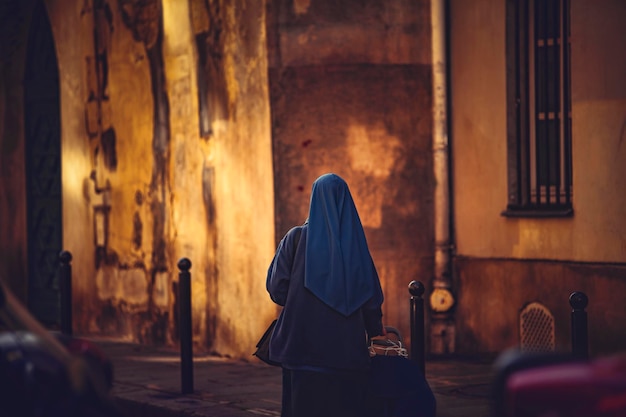 Vista trasera de una mujer con hijab de pie en el interior