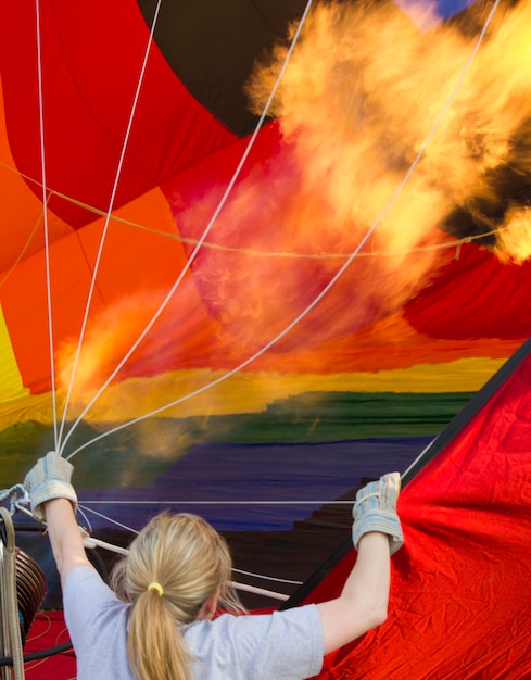 Foto vista trasera de una mujer inflando un globo de aire caliente