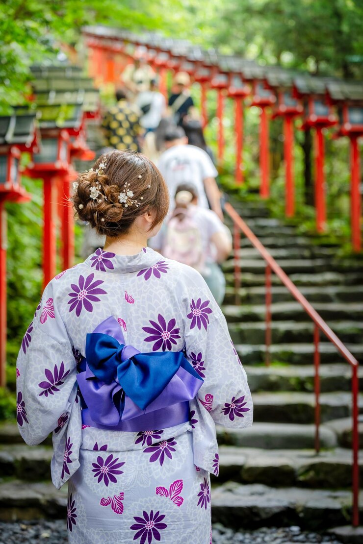Vista trasera de una mujer con un kimono de verano yukata japonés en la puerta de las escaleras del santuario de Kifune en Kioto, Japón