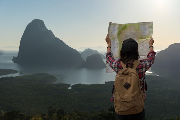 Foto vista trasera de una mujer leyendo un mapa mientras está de pie en la montaña