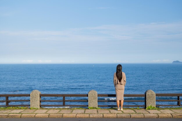 Vista trasera de la mujer mirando al mar