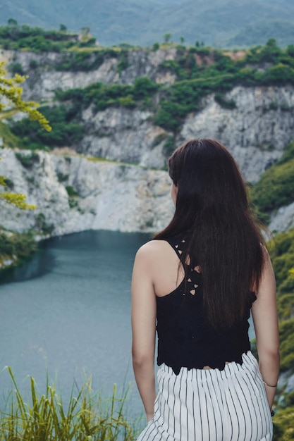 Foto vista trasera de una mujer mirando una cascada