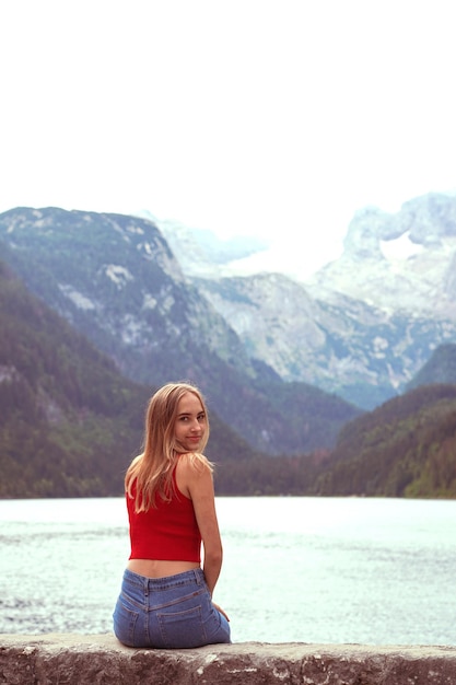 Foto vista trasera de una mujer mirando el lago contra la montaña