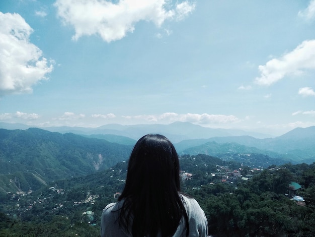 Foto vista trasera de una mujer mirando las montañas contra el cielo