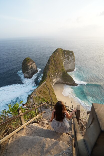 Vista trasera de una mujer mirando la orilla del mar contra el cielo