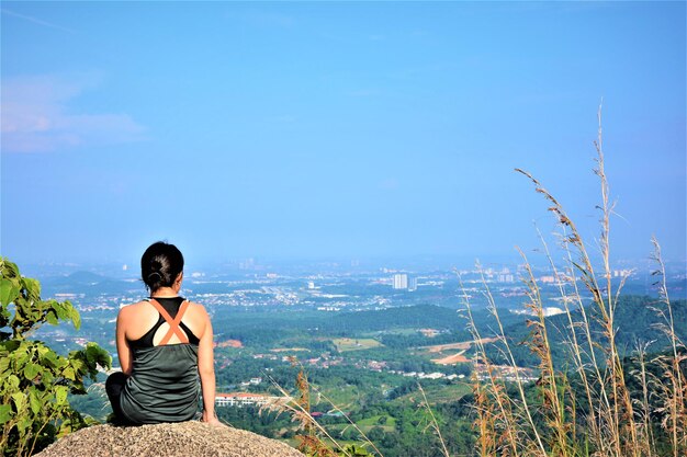 Foto vista trasera de una mujer mirando el paisaje contra el cielo azul