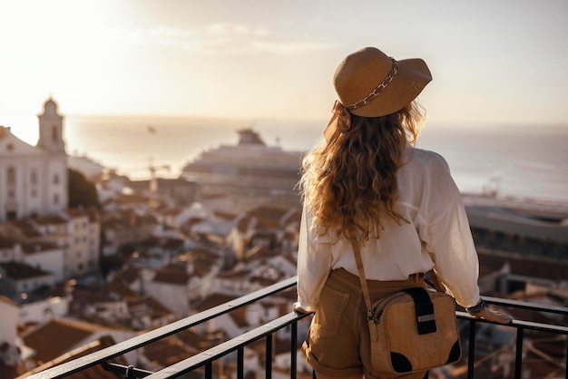Vista trasera de una mujer mirando el paisaje urbano contra el cielo