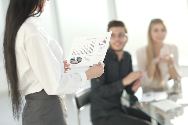 Vista trasera. mujer de negocios con horario financiero de pie en la sala de conferencias. concepto de negocio