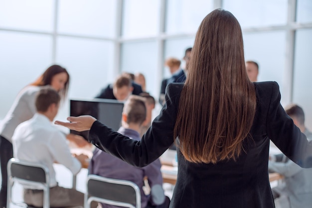 Vista trasera mujer de negocios mirando al personal de la oficina