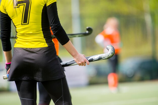 Vista trasera de una mujer con un palo de hockey