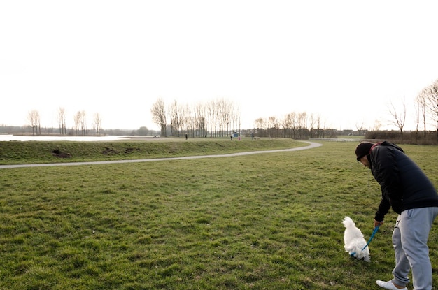Foto vista trasera de una mujer con un perro en el campo contra el cielo