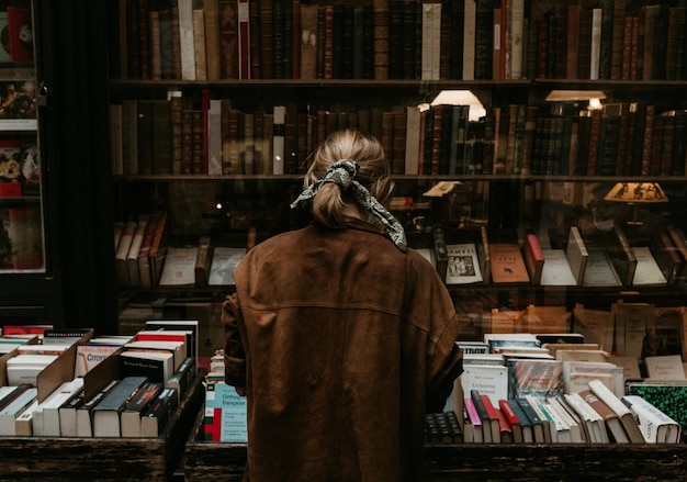 Vista trasera de una mujer de pie en la biblioteca