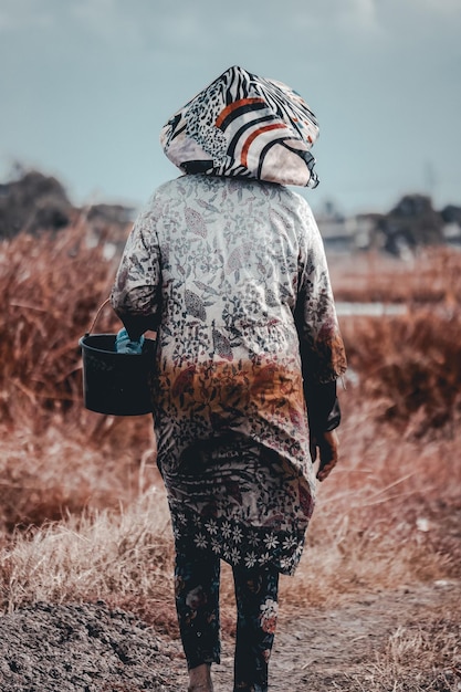 Foto vista trasera de una mujer de pie en el campo