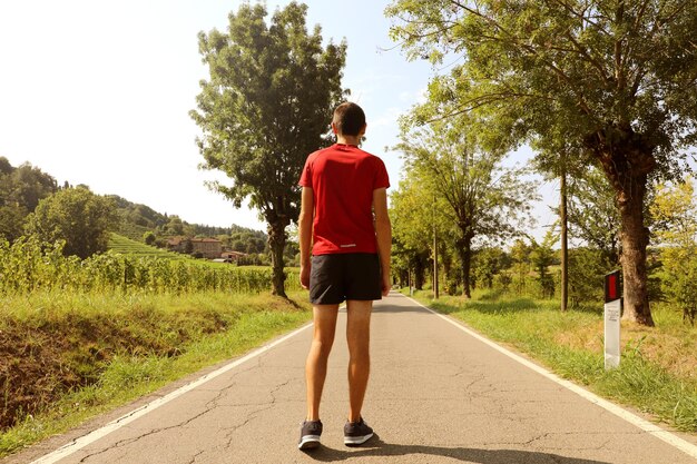 Vista trasera de una mujer de pie en la carretera