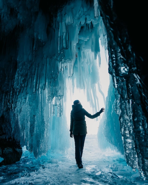 Foto vista trasera de la mujer de pie en la cueva