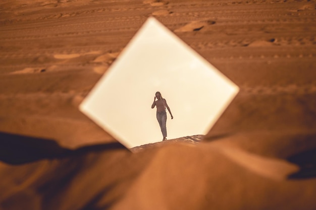 Foto vista trasera de una mujer de pie en el desierto