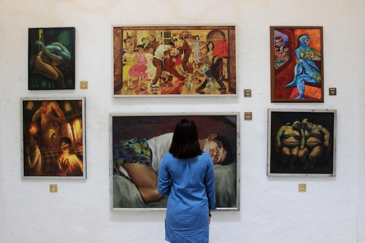 Foto vista trasera de una mujer de pie frente a las pinturas