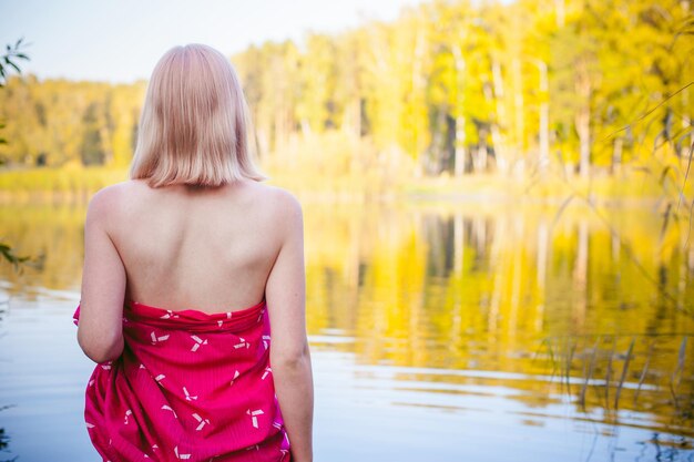 Foto vista trasera de una mujer de pie junto al lago