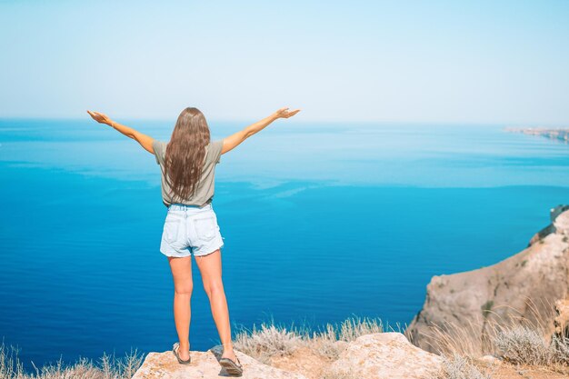 Foto vista trasera de una mujer de pie junto al mar contra el cielo