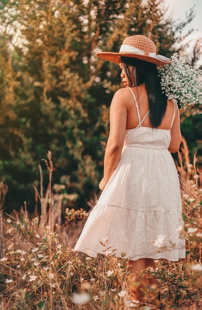 Foto vista trasera de una mujer de pie junto a las plantas