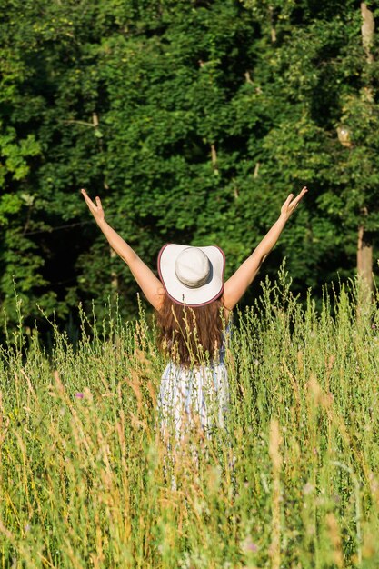 Foto vista trasera de una mujer de pie en medio de las plantas en el campo