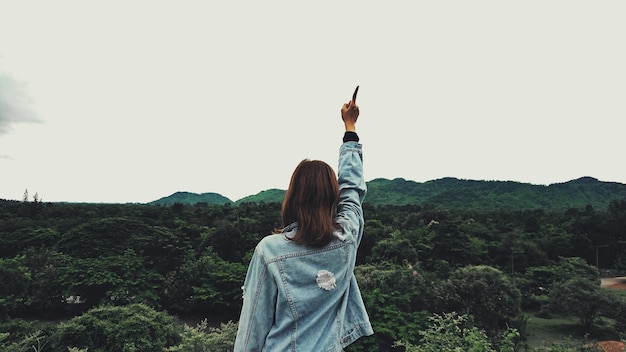 Foto vista trasera de una mujer de pie en la montaña contra el cielo