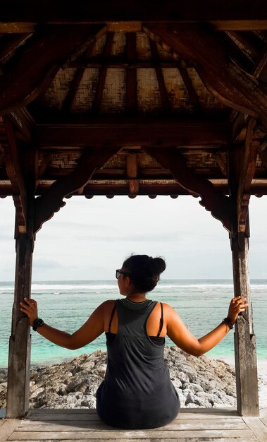 Foto vista trasera de una mujer de pie en la playa