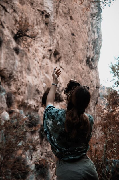 Foto vista trasera de una mujer de pie en una roca