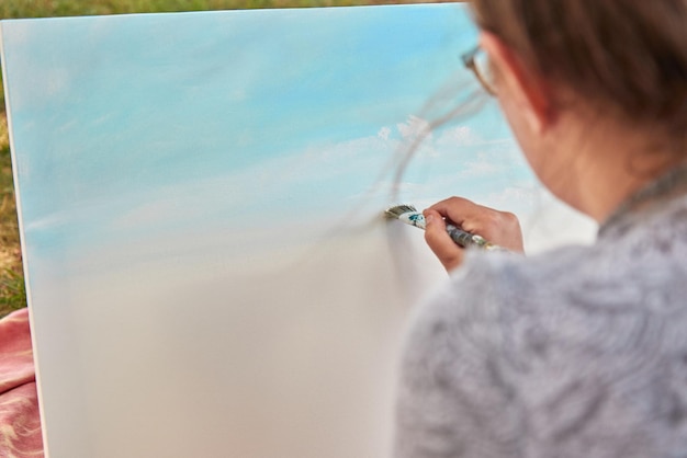 Foto vista trasera de una mujer pintando al aire libre