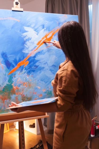 Foto vista trasera de una mujer pintando en casa