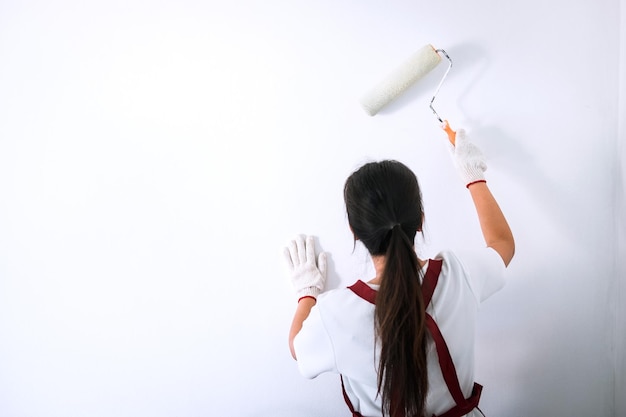 Foto vista trasera de una mujer pintando la pared en casa