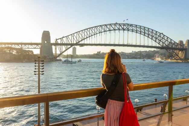 Foto vista trasera de la mujer en el puente contra el cielo