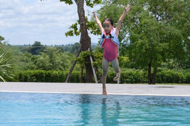 Vista trasera de una mujer saltando en la piscina